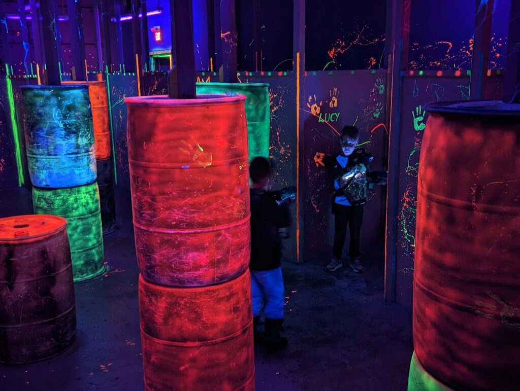 Barrels and black-lit walls inside the laser tag arena